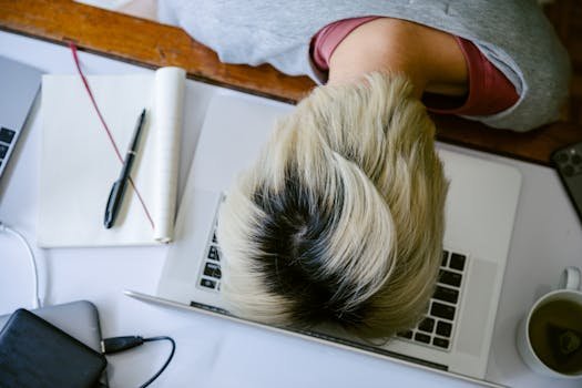 pexels photo 4126694 4126694 From above of tired fatigued unrecognizable female in casual wear resting head on netbook keyboard near notebook and cup of tea after long working day
