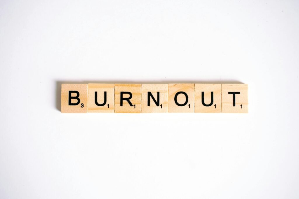Conceptual image of 'Burnout' spelled with Scrabble tiles on a white background.