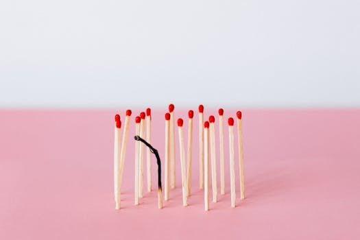 pexels photo 6837623 6837623 Artistic representation of burnout with matchsticks on a pink surface in a studio setting.